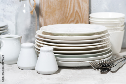 empty tableware, cutlery and kitchen utensils on white table