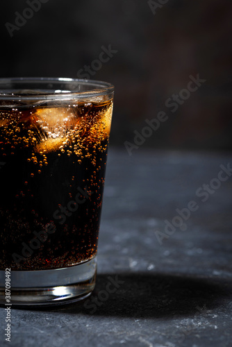 glass of coca cola with ice on a black background, vertical