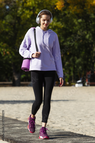 Ready to work. Young female athlete, woman training, practicing outdoors in autumn sunshine. Beautiful caucasian sportswoman walking open-air. Concept of sport, healthy lifestyle, movement, activity.