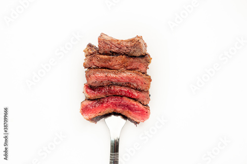 
Different degrees of doneness of steak on a fork for meat on a white background
