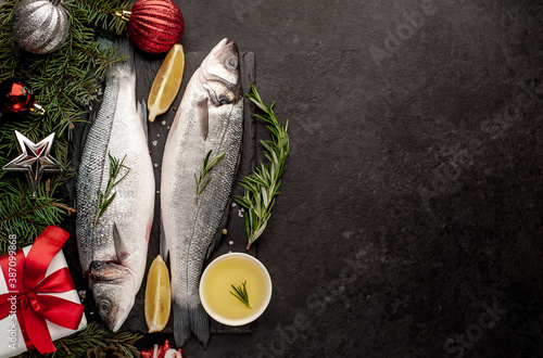 Photography Raw sea bass fish with spices for the Christmas holiday on a stone background wi