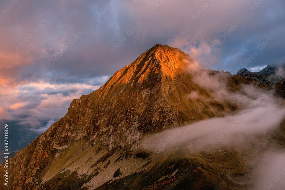 Mount Black Pyramid at Krasnaya Polyana in Sochi. Mountainous relief at sunset. Cloudy in the mountains.
