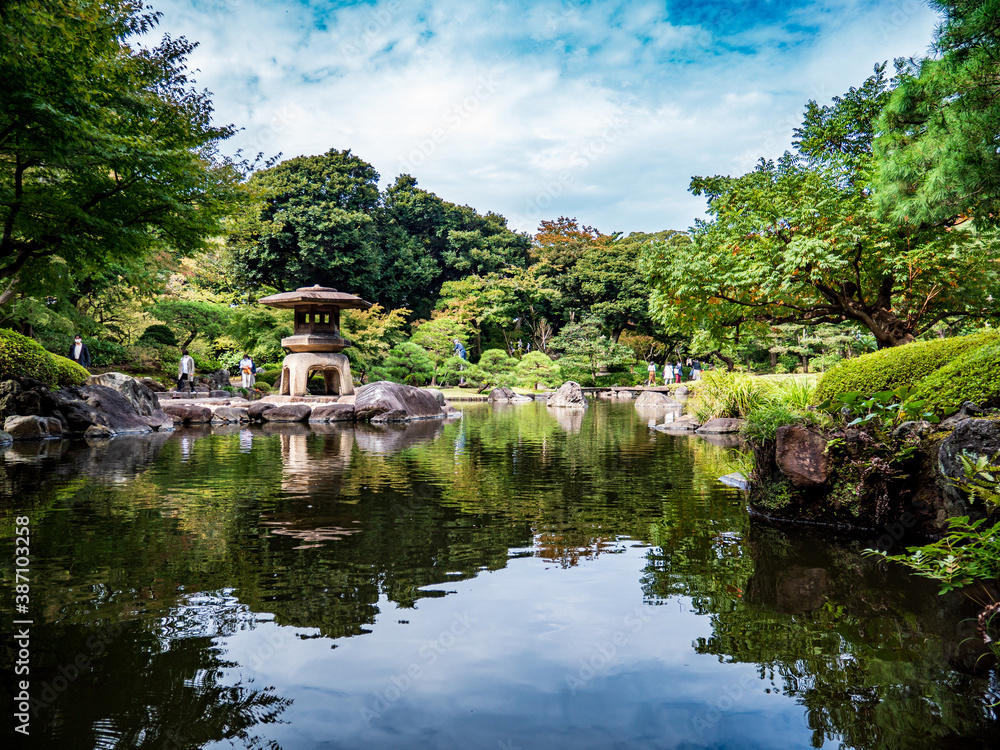 池のある、秋の日本の伝統的な庭園の風景