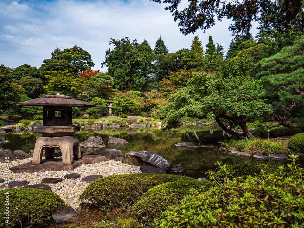 池のある、秋の日本の伝統的な庭園の風景