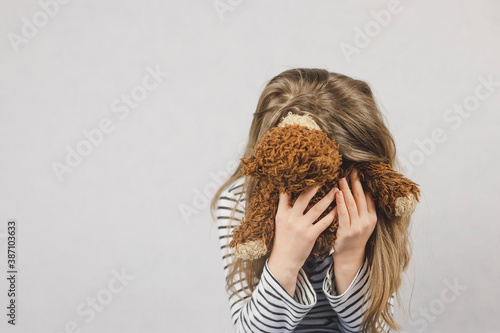 Fototapeta Naklejka Na Ścianę i Meble -  Upset girl schoolgirl, teenager buried her face in a teddy bear. Teenage depression, suicidal thoughts, misunderstanding of parents. Mental health