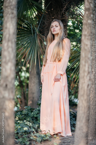 Portrait of a young,  gorgeous woman with beautiful long hair in summer park.