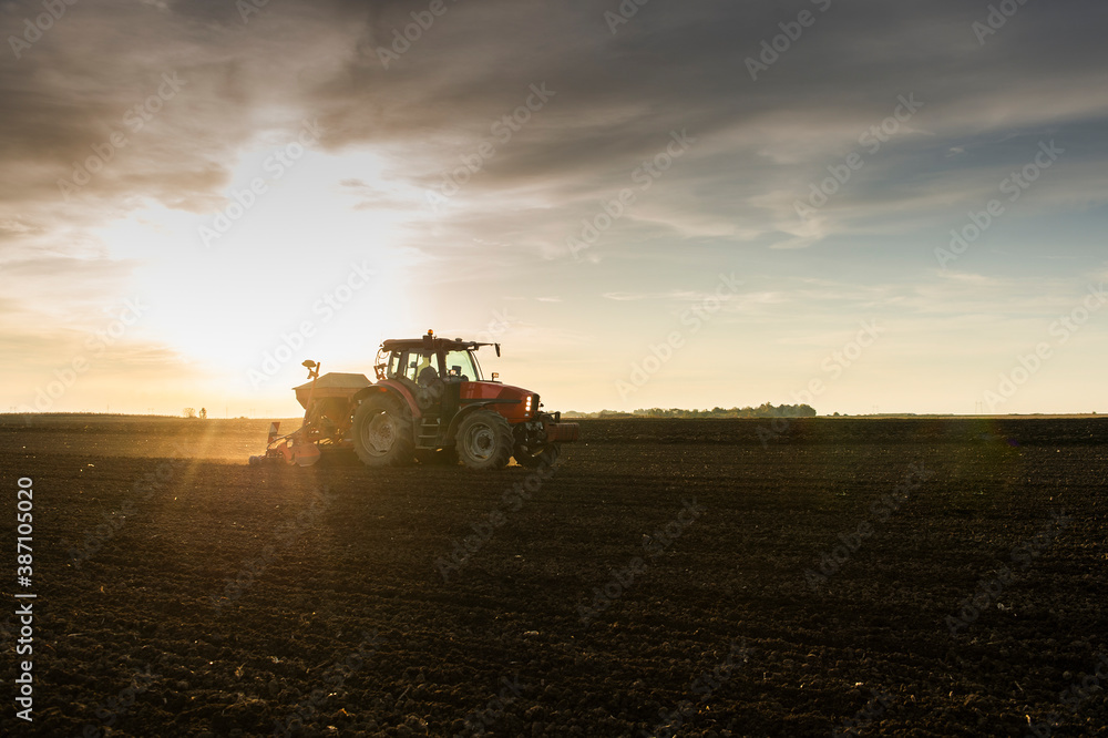 Fototapeta premium Farmer with tractor seeding