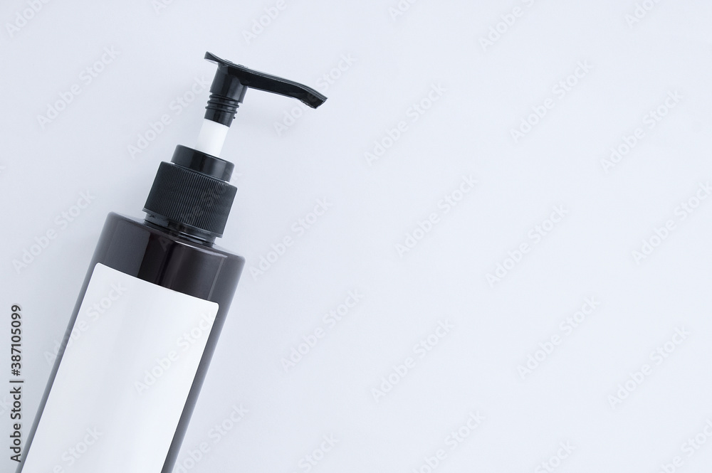 Plastic brown dispenser bottle with white label close-up on a white background. Place for text. Plastic brown dispenser bottle with white label close-up on a white background. Place for text.