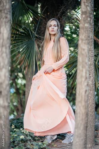 Portrait of a young,  gorgeous woman with beautiful long hair in summer park.