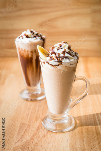 Iced coffee milkshake on a wood table with a wood background © JonMilnes