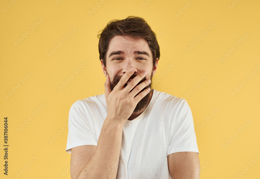 Portrait of a guy in a t-shirt and a brunet beard model yellow background Portrait of a guy in a t-shirt and a brunet beard model yellow background