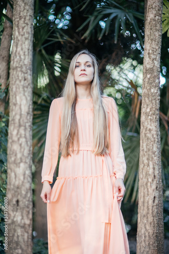 Portrait of a young,  gorgeous woman with beautiful long hair in summer park.
