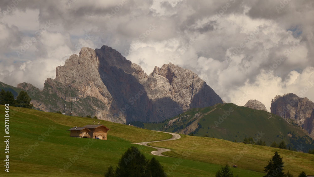 Landscape in the mountains with small white road and a hut. Alpe di Siusi. Odle. Dolomites. Italy