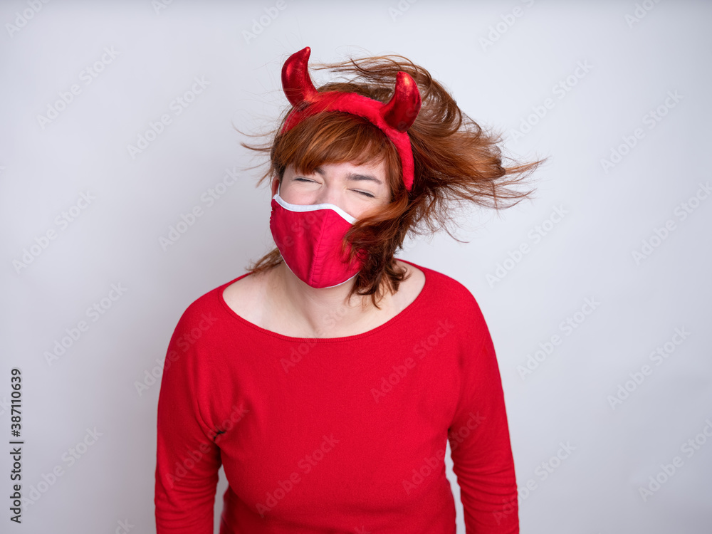 Junge Frau mit einem Faschingskostüm wehrt sich gegen das Tragen eines Mundschutzes