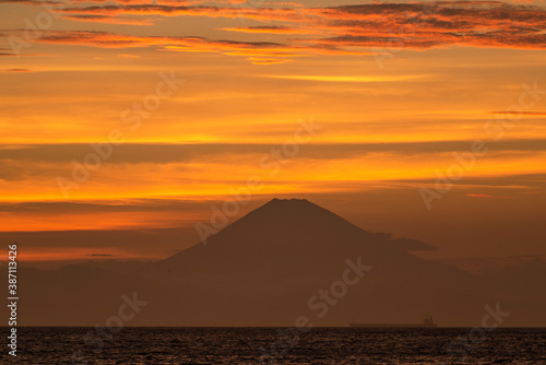 真っ赤な夕焼け雲を背にした洋上の富士山