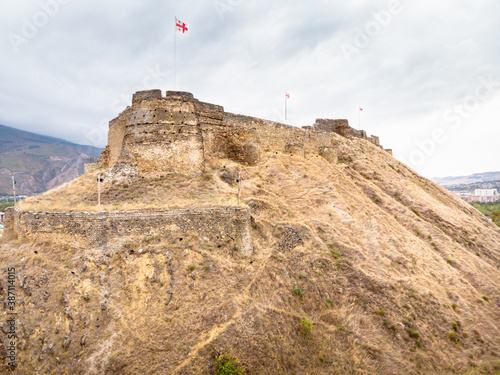 Aerial view to Gori castle walls with Georgian flags on top. Histoprical places in Caucasus.