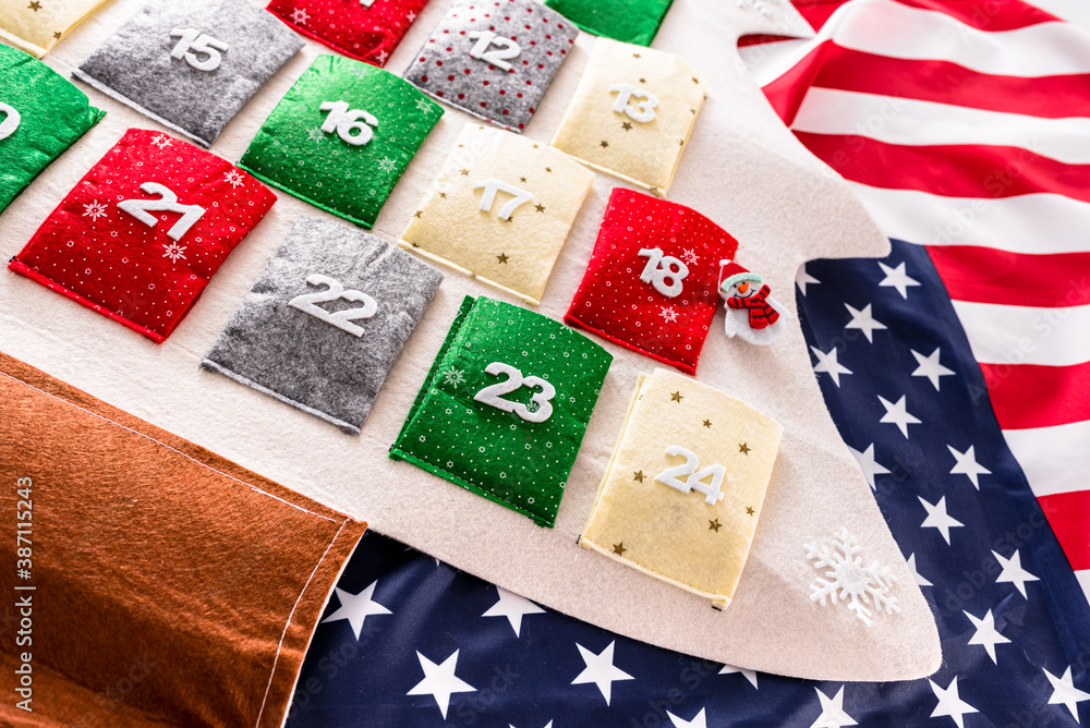 Obraz premium Traditional advent calendar with December 24 in the foreground over American flag