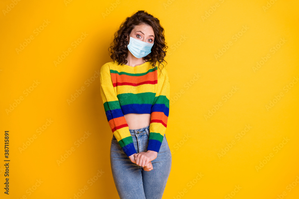 Photo portrait of girl holding hands look camera wear respiratory mask isolated on vivid yellow colored background Photo portrait of girl holding hands look camera wear respiratory mask isolated on vivid yellow colored background