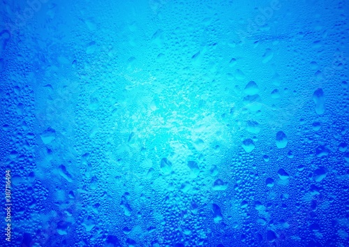 青い水滴が付着したガラスの抽象的な背景
