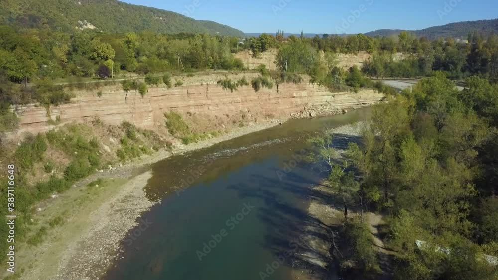 Calm slow mountain river. The drone slowly flies over the surface of the river Calm slow mountain river. The drone slowly flies over the surface of the river