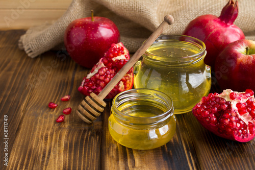 Honey, pomegranate and red apples on the wooden rustic  background