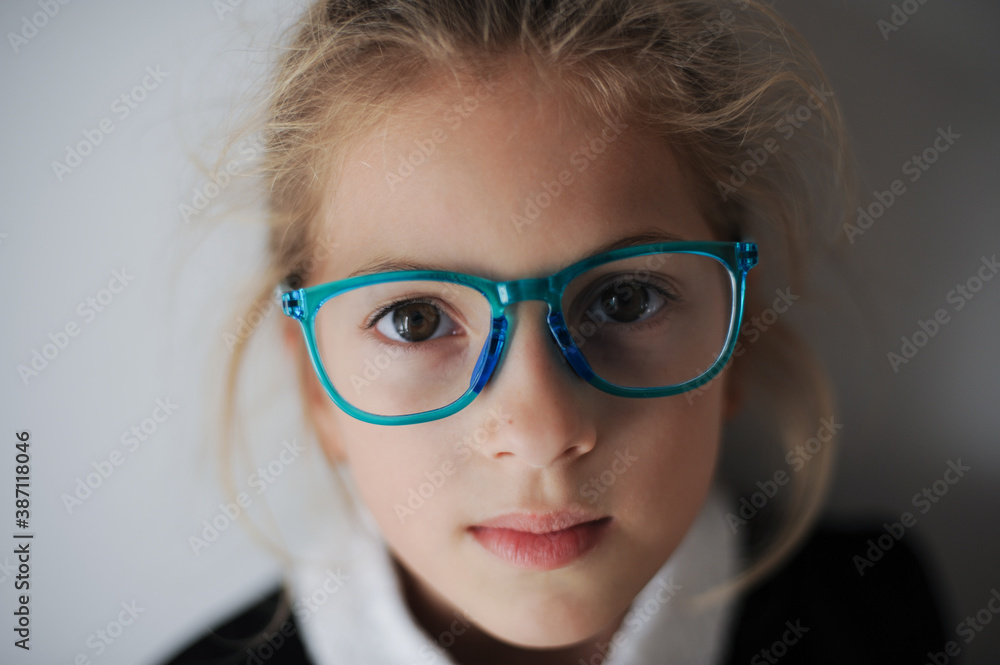 beautiful clever little girl wearing black and white school uniform in blue glasses beautiful clever little girl wearing black and white school uniform in blue glasses