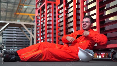 Worker suffering from a heat stroke or heart attack and falling on the ground in the factory. Safety at work photo