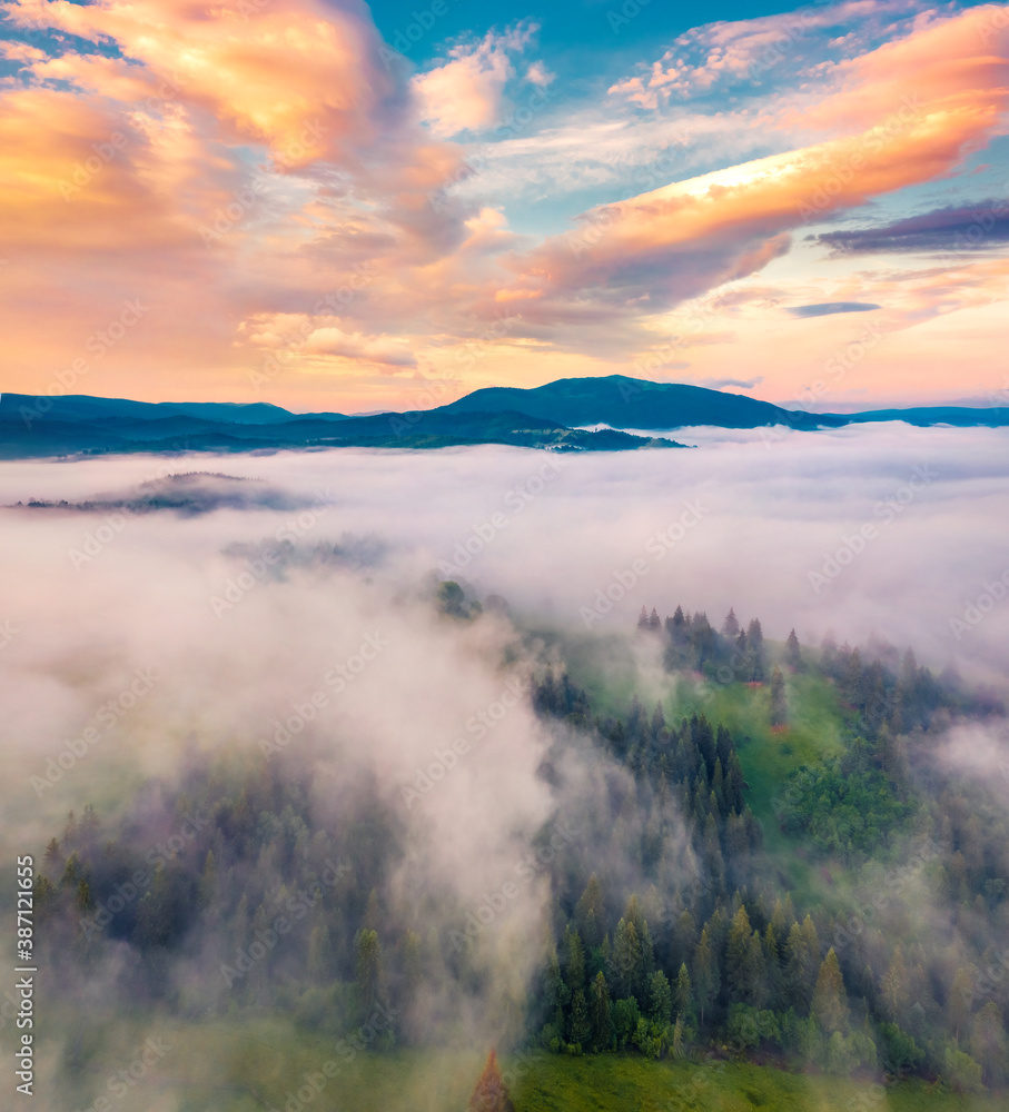 View from flying drone. Unbelievable morning scene of Carpathian mountains. Spectacular sunrise on foggy mountain valley. Beauty of nature concept background.