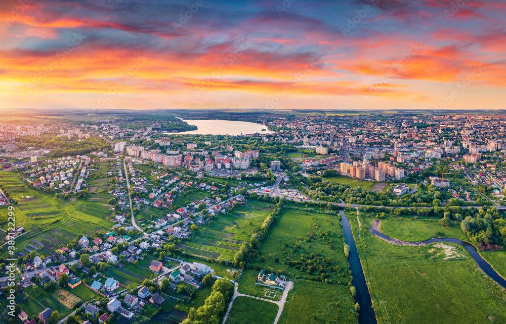 Fototapeta premium View from flying drone of Ternopil city. Astonishing summer sunrise on Seret river. Beautiful morning cityscape of Ternopil, Ukraine. Traveling concept background...