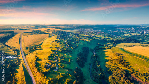 View from flying drone of outskirts of Buchach town, Ternopil region, Ukraine. Sunny aerial scene of countryside with Strypa river and asphalt road. Traveling concept background.. photo