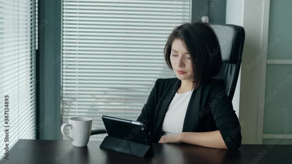 Woman having troubles with work or app crash. Young business lady sitting behind the desk with tablet, shaking head, being dissapointed and tired. Concept of freelance, startup, entrepreneur. Woman having troubles with work or app crash. Young business lady sitting behind the desk with tablet, shaking head, being dissapointed and tired. Concept of freelance, startup, entrepreneur.