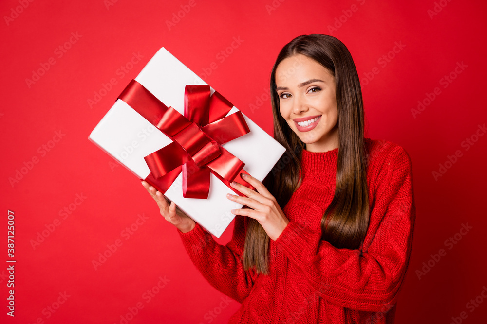 Photo of positive girl hold big christmas gift box wear pullover jumper isolated over bright shine color background Photo of positive girl hold big christmas gift box wear pullover jumper isolated over bright shine color background