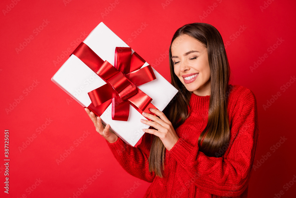 Photo of positive girl enjoy get christmas gift box isolated over red shine color background Photo of positive girl enjoy get christmas gift box isolated over red shine color background
