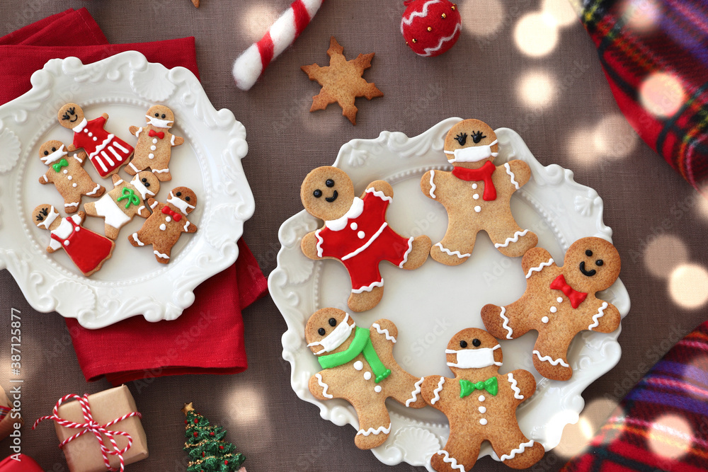 Obraz premium Gingerbread man cookies with protective face mask and drink on Christmas decoration table. Christmas and new year concept in new normal. Top view, Flat lay.マスクをしたジンジャーマンクッキー クリスマスギフト