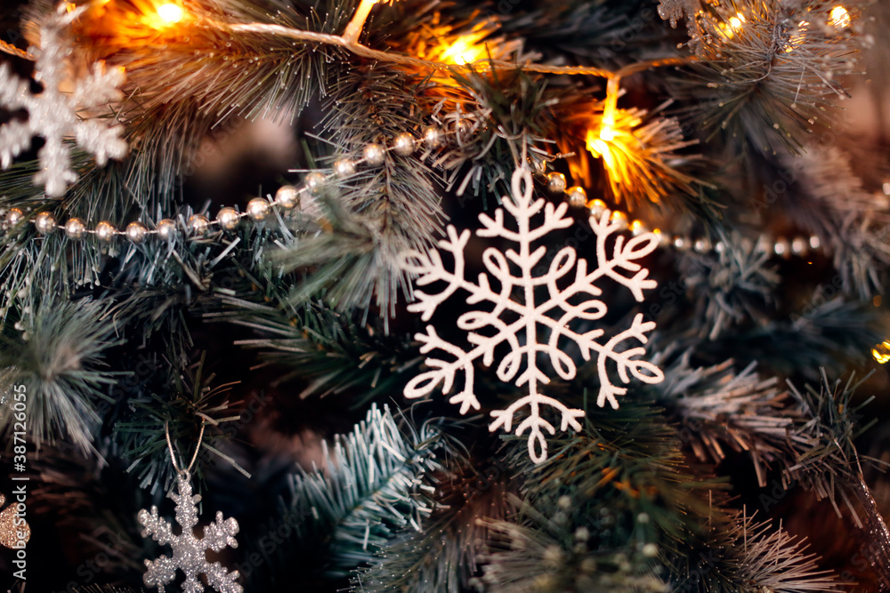 Christmas silver snowflake toys on a Christmas tree close-up. Christmas and New Year, background Christmas silver snowflake toys on a Christmas tree close-up. Christmas and New Year, background