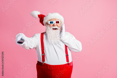 Portrait of his he nice attractive cheerful cheery glad amazed fat Santa watching film video switching channel enjoying pastime amusement air blow wind isolated pink pastel color background