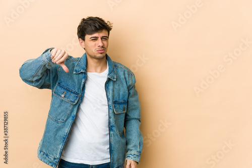 Young cool man showing thumb down, disappointment concept.
