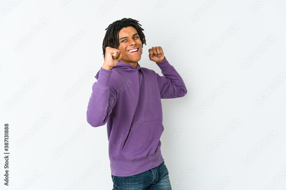 Young african american rasta man raising fist after a victory, winner concept. Young african american rasta man raising fist after a victory, winner concept.