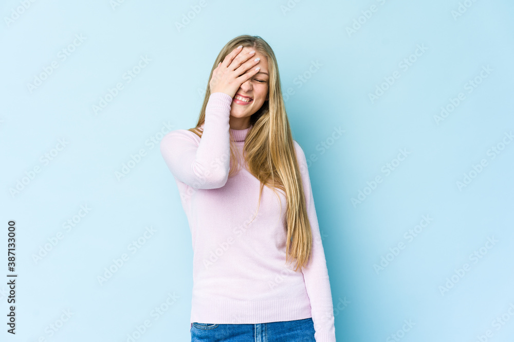 Young blonde woman isolated on blue background laughing happy, carefree, natural emotion. Young blonde woman isolated on blue background laughing happy, carefree, natural emotion.