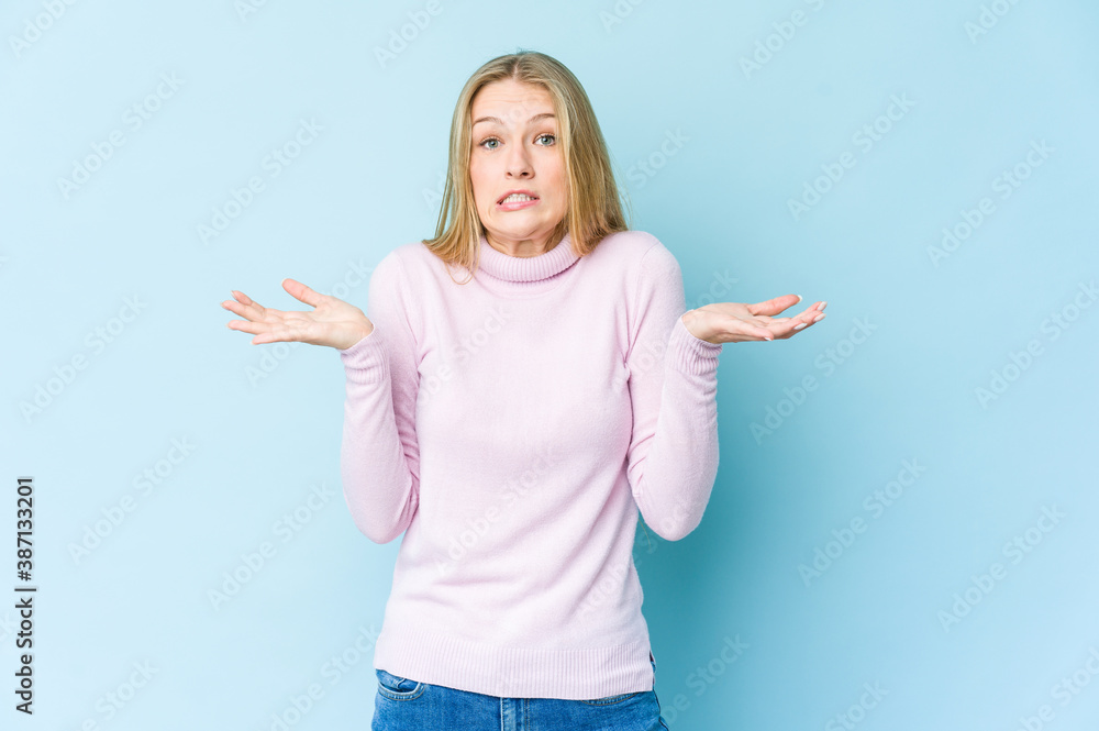 Young blonde woman isolated on blue background surprised and shocked. Young blonde woman isolated on blue background surprised and shocked.