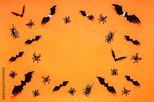 Halloween composition. Black bats, spiders, flies and bugs on orange background. Happy Halloween, trick or treat party concept. Flat lay, top view, copy space © Tatyana_Andreyeva