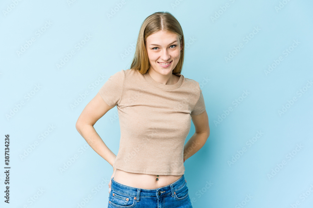 Young blonde woman isolated on blue background happy, smiling and cheerful. Young blonde woman isolated on blue background happy, smiling and cheerful.