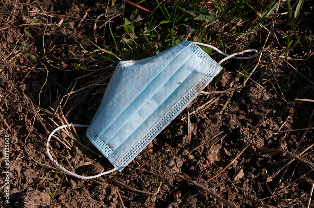 used face mask drop on ground grass floor, save the nature. garbage. in time of coronavirus used face mask drop on ground grass floor, save the nature. garbage. in time of coronavirus