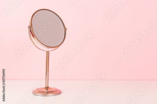 Gold mirror on pink background. Vanity table concept. Minimal composition. Copy space for your text.