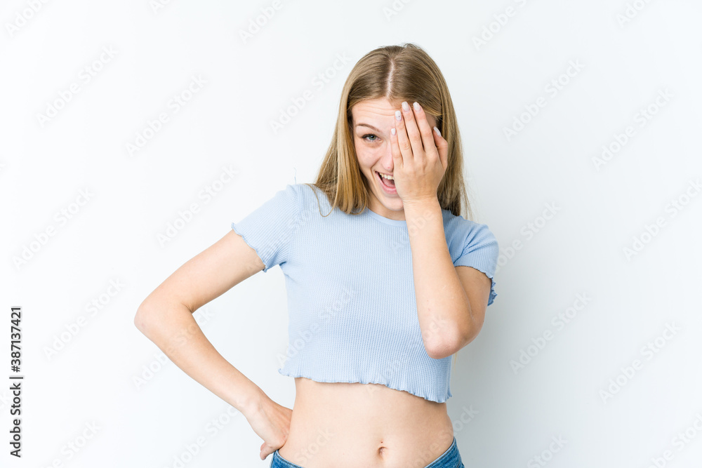 Young blonde woman isolated on white background having fun covering half of face with palm. Young blonde woman isolated on white background having fun covering half of face with palm.