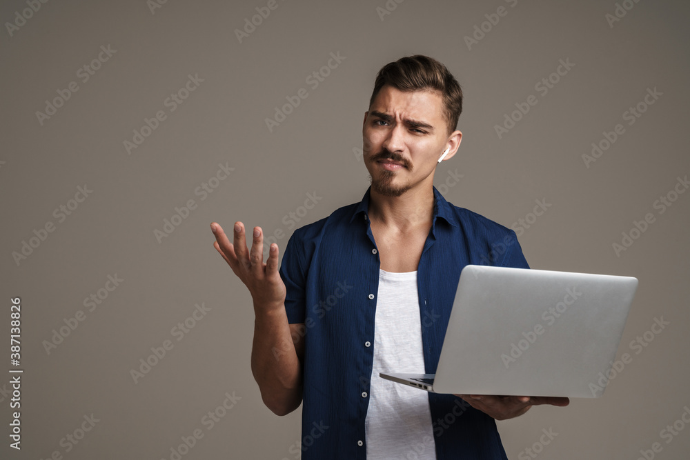 Confused young man using laptop computer Confused young man using laptop computer