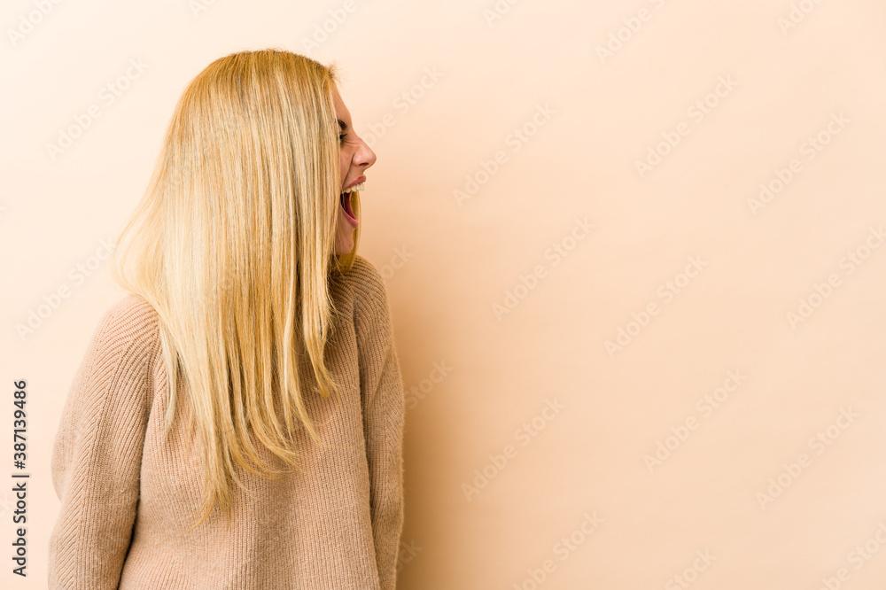 Young blonde caucasian woman shouting towards a copy space Young blonde caucasian woman shouting towards a copy space