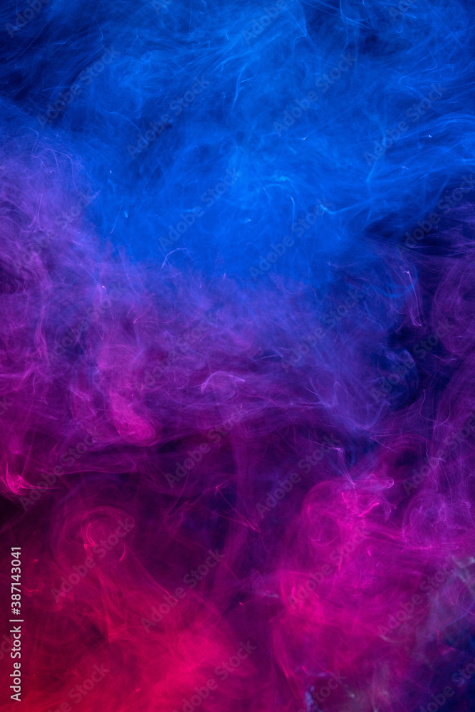 Conceptual image of colorful red and blue color smoke on dark black background.