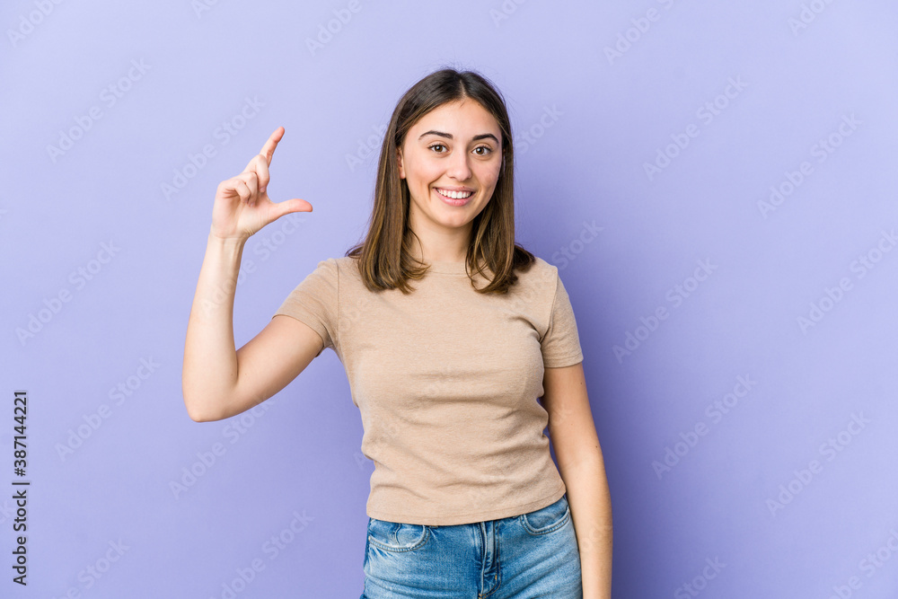 Young caucasian woman holding something little with forefingers, smiling and confident. Young caucasian woman holding something little with forefingers, smiling and confident.
