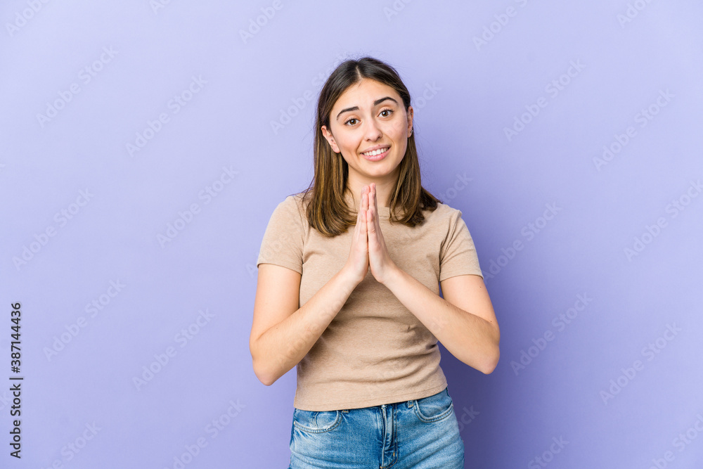 Young caucasian woman holding hands in pray near mouth, feels confident. Young caucasian woman holding hands in pray near mouth, feels confident.
